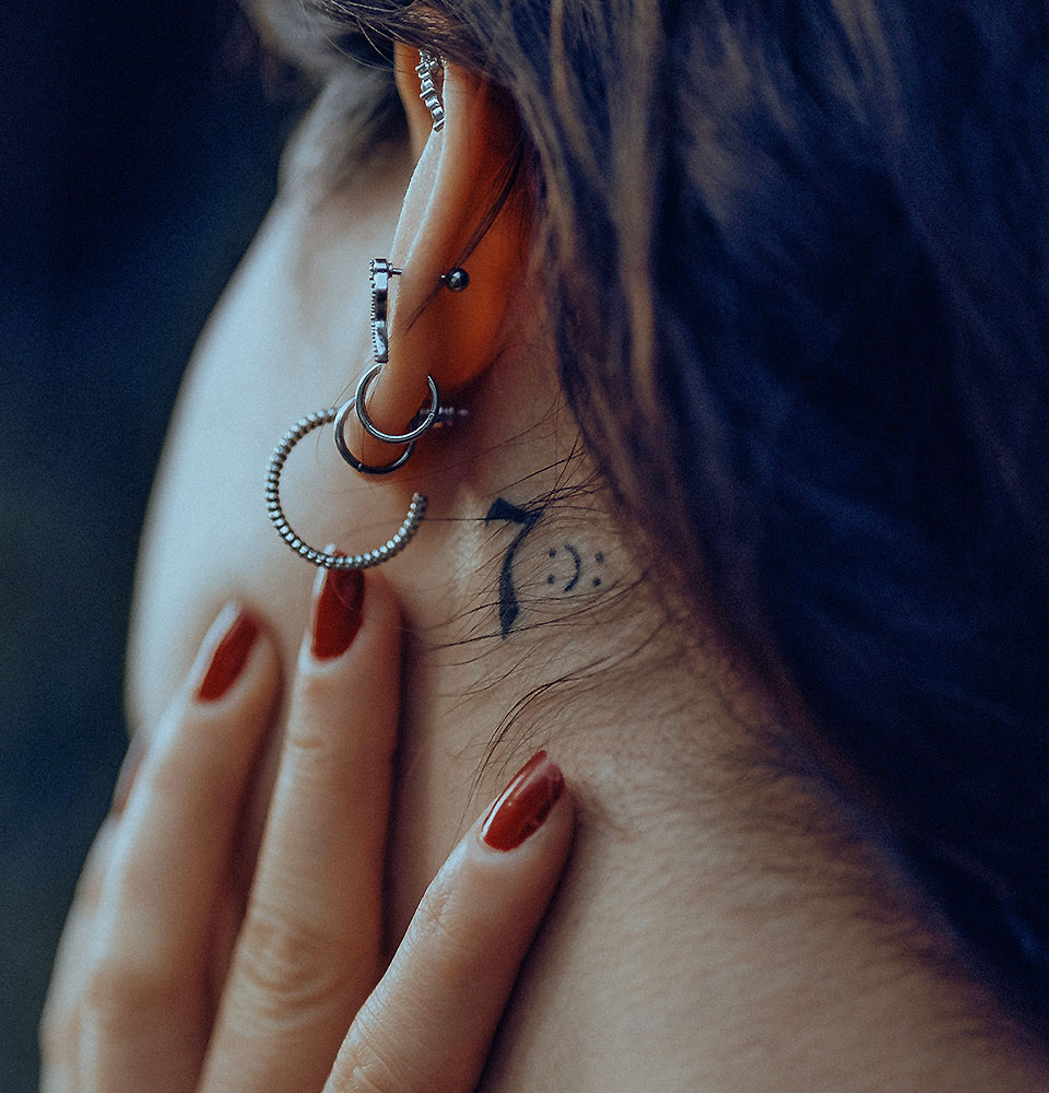 Woman with Small Tattoo Behind Ear Woman with Small Tattoo Behind Ear